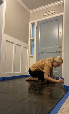 a woman kneeling on the floor in front of a door