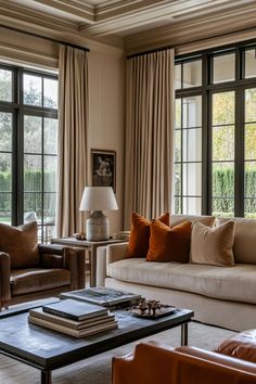 a living room filled with furniture and windows covered in brown drapes on top of them