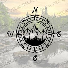 a compass with mountains and trees on it in the middle of a river surrounded by forest