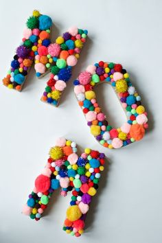 the letters are made out of pom - poms