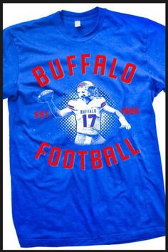 Buffalo Football Shirt. A homage shirt to our new franchise QB. A great shirt for some one who is Buffalo Football fan too! All of our shirts are printed on high quality, ultra soft, 100% cotton preshrunk American Apparel t-shirts. All printing is done in-house and is American made. Main design is on front. for more shirts visit our site: www.mybuffaloshirt.com Tri-blend T-shirt With Graphic Print For Fans, Crew Neck T-shirt With Screen Print For Fan Events, Team Spirit T-shirt With Screen Print For Fan Gear, Fan Merchandise Logo Print T-shirt, Graphic Tee For Fan Events With Screen Print, Tri-blend Graphic Tee For Fan Merchandise, Graphic Tee With Screen Print For Fan Events, Graphic Tee Tops For Fan Events With Screen Print, Fan Merchandise Crew Neck T-shirt With Screen Print