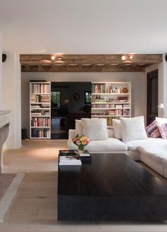 a living room filled with furniture and a fire place in front of a book shelf