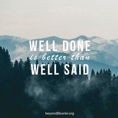 the words well done is better than we said on top of a mountain with trees