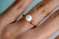 Bridal jewelry ~ Bridesmaid jewelry ~ Classic pearl ring. Beautiful pearl ring with double prong detail in 14k rose gold plating and imitation pearl accent. Dainty, feminine and classic - this ring is a perfect gift for bridesmaids, bridal showers, and birthdays! Adjustable one size up or down. Add gift wrap for $3.00 at checkout! Your present will be in a jewelry box wrapped in colorful patterned paper with glitter pom poms! It comes nicely wrapped in tissue paper, sealed with a sticker, and re Minimalist Rose Gold Pearl Promise Ring, Stackable Rose Gold Pearl Ring, Dainty 14k Rose Gold Pearl Ring, Minimalist Rose Gold Pearl Wedding Ring, Elegant Stackable Rose Gold Pearl Ring, Minimalist Rose Gold Pearl Ring, Dainty Adjustable Stackable Pearl Ring, Minimalist Rose Gold Pearl Ring Gift, Elegant Rose Gold Stackable Pearl Ring