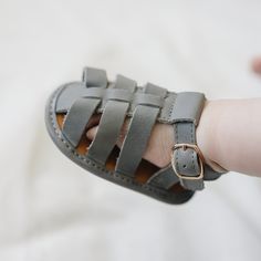 ***Looking for a larger size? Click HERE to see this same style with larger sizes in a hard sole.*** Introduce your little one to stylish comfort with our Gray Fisherman Sandals, available in US sizes 2-4. These adorable sandals are perfect for early walkers, combining the classic fisherman design with a soft sole for maximum comfort and flexibility. Crafted from genuine leather, they offer a delightful blend of style, quality, and ease of wear. Key Features: Classic Design: The timeless fisherm Cheap Leather Flat Fisherman Sandals, Cheap Leather Fisherman Sandals With Buckle, Luxury Fisherman Sandals For Women, Spring Season, High-end Classic Fisherman Sandals With Buckle Closure, Leather Fisherman Sandals, Fisherman Sandals, Family Picnic, Mary Jane Flats, Cute Sandals