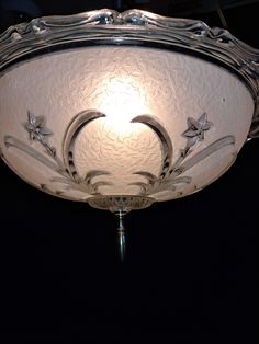 a light that is hanging from the ceiling in a dark room with stars and crescents on it