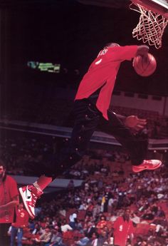 a man jumping up into the air to dunk a basketball in front of an audience