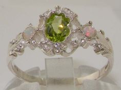 *This ring is made from 925 Sterling Silver with Natural Peridot & Opals.PLEASE MAKE SURE YOU STATE THE FINGER SIZE YOU REQUIRE WITH YOUR PAYMENT.This stunning ring has been set with a center 6x4mm (0.24" x 0.16") Peridot and two Fiery Opals on the shoulders measuring 2.25mm (0.09"). The contrast of the Vibrant Green Peridot with these colorful Pretty Opals set within this delicate yet strong setting, creates such an elegant look and feel, this ring is certainly a very special piece. The des Cute Engagement Rings, Trilogy Ring, Green Peridot, Cute Rings, Pretty Rings, Natural Earth, Delicate Rings, Vibrant Green, Jewelry Inspo