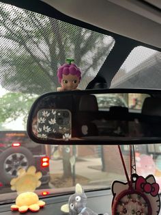 there is a car mirror with some toys on it