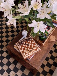 a vase with flowers and chess board on a coffee table