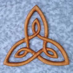 a wooden brooch sitting on top of a blue surface