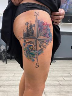 a woman with a compass tattoo on her thigh