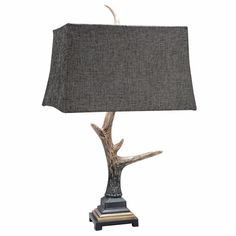 a lamp that is sitting on top of a wooden base with a black shade over it