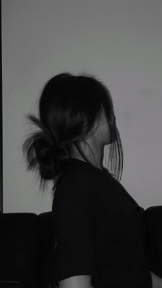 black and white photograph of a woman sitting on a couch with her hair blowing in the wind