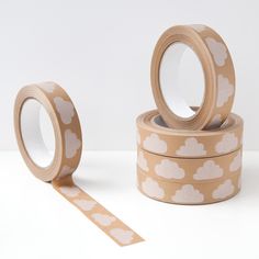 two rolls of washi tape with white clouds on them, one roll is brown