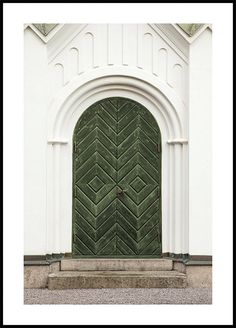 a green door is in front of a white building with an arched doorway and stone steps