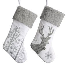 two white christmas stockings with grey trim and silver reindeers on them, one is hanging from the ceiling