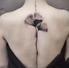 a woman's back with a flower tattoo on it