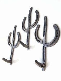 three metal cactus hooks on a white background