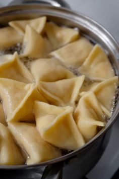 some dumplings are cooking in a pot on the stove