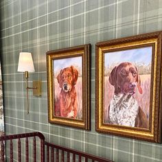 two paintings of dogs hang on the wall next to a crib