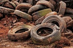 an old pile of tires sitting on top of dirt