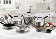 pots and pans sitting on a kitchen counter top with utensils in front of them