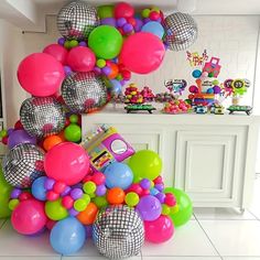 a bunch of balloons and disco balls are on the floor in front of a counter