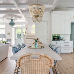 a dining room table with wicker chairs and a basket on the back of it