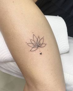 a woman's leg with a small flower tattoo on the left side of her arm