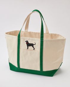 a large canvas bag with a black dog on the front and green trimmings