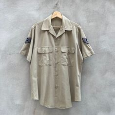 Size: L Chest - 23in Length - 31in Sleeve - 9.75in General wear, check all measurements before purchasing, no refund will be allowed all information is provided in each description. Bowling style shirt, made in USA, military issued, dated 1969, no major flaws, arm patches shown, nice khaki color way, all buttons, attached, lightweight cotton blend, no flaws Military Style Short Sleeve Cotton Shirt, Military Style Cotton Shirt With Short Sleeves, Military Style Cotton Short Sleeve Shirt, Military Style Short Sleeve Shirt With Pockets, Khaki Military Style Short Sleeve Shirt, Khaki Military Short Sleeve Shirt, Khaki Short Sleeve Military Shirt, Military Style Short Sleeve Top With Button Closure, Military Style Collared Top With Snap Buttons