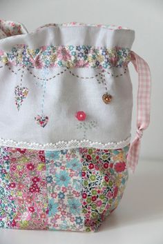 an image of a purse made out of fabric with flowers and buttons on the front