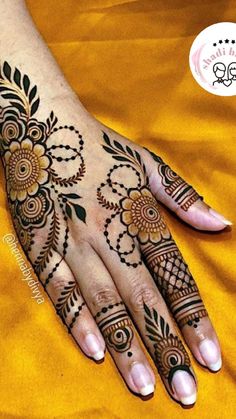 a woman's hand with henna tattoos on it