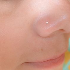 a woman's nose with a small white dot on the tip of her nose