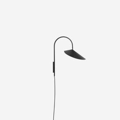 a black lamp on a white background with the light turned off to show its dim lighting