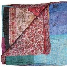 a multicolored patchwork blanket folded on top of each other