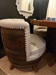 a wooden barrel chair sitting in front of a mirror