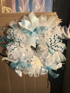 a blue and white wreath hanging on the front door