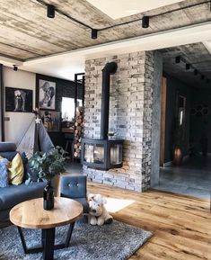 a living room filled with furniture and a fire place in the middle of it on top of a hard wood floor