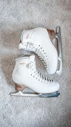 a pair of white ice skates sitting on the ground