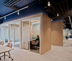 an office with a woman sitting at a desk in front of a sliding glass door