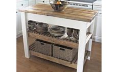 a kitchen island with baskets on it and plates in the bottom drawer, next to an oven