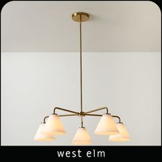 the west elm chandelier has three white lamps hanging from it's arms