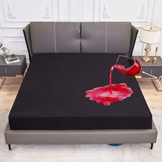 a bed with a black cover and red liquid pouring out of the top on it