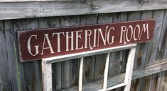 there is a sign that says gathering room on the side of a wooden building with windows