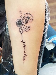 a woman with a tattoo on her arm that says, love and has flowers growing out of it