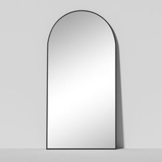 an arch shaped mirror on the wall