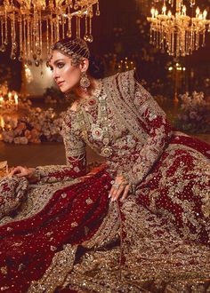 Long Kameez Red Lehenga Pakistani Wedding Dresses are Captured in a traditional silhouette. The bridal stands out due to its uniqueness and the perfect fusion of modern cut and traditional embroidery in Chiffon Lehnga and Kameez paired with Net Dupatta. Long Bridal Kameez: This dress is beautifully highlighted with zardozi work in shades of tan and golden. The shirt's hemline is adorned with a scalloped finish and tassels on the sleeves. The hemline is even more enhanced with bird motifs finishe Traditional Wedding Dress With Dabka Work For Reception, Red Gown With Intricate Embroidery For Traditional Ceremonies, Anarkali Style Traditional Drape Wedding Dress, Anarkali Wedding Dress With Resham Embroidery For Traditional Ceremonies, Anarkali Style Wedding Dress For Traditional Ceremonies, Red Dabka Lehenga For Reception, Traditional Wedding Dress With Pallu For Eid, Red Gown For Eid And Traditional Ceremonies, Traditional Embroidered Wedding Dress For Eid