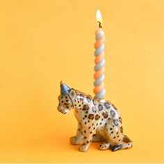 a leopard figurine with a candle in the shape of a cat